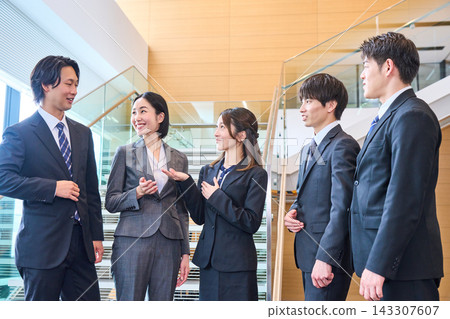 A business team chatting with smiles on their faces in the stairwell. A business team chatting with smiles on their faces in the stairwell. 143307607