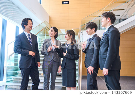 A business team chatting with smiles on their faces in the stairwell. A business team chatting with smiles on their faces in the stairwell. 143307609