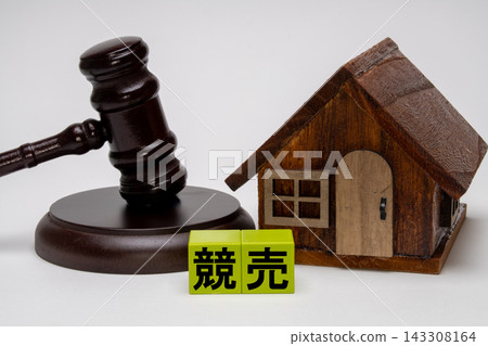 An image of a real estate auction represented by a gavel and a model house. An image of a real estate auction represented by a gavel and a model house. 143308164