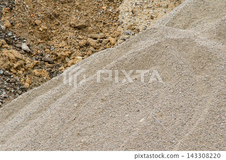 Various types of building gravel, a mixture of large and small stones. A damp soil texture. 143308220