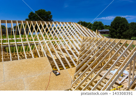 Workers build wooden frame structure with complex roof design Workers build wooden frame structure with complex roof design 143308391
