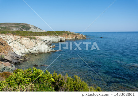 Scenic rocky cliffs lining the coast of North Corsica above the clear Mediterranean Sea Scenic rocky cliffs lining the coast of North Corsica above the clear Mediterranean Sea 143308801