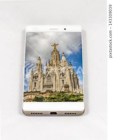 Smartphone displays Sagrat Cor church, Barcelona, with Christ statue against Smartphone displays Sagrat Cor church, Barcelona, with Christ statue against 143309039