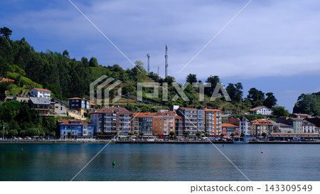 Scenic wide-angle view of the charming coastal town of Ribadesella in Asturias, Spain, nestled along a calm river estuary. Scenic wide-angle view of the charming coastal town of Ribadesella in Asturias, Spain, nestled along a calm river estuary. 143309549