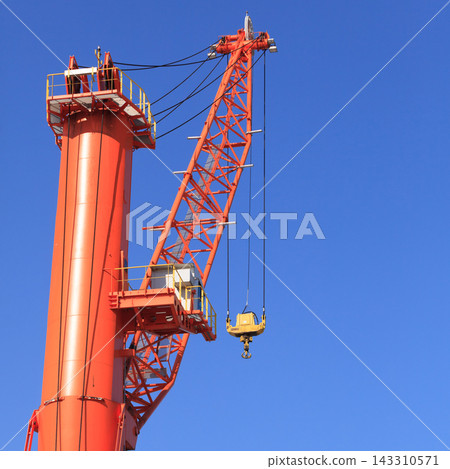 Orange Construction Crane Boom Against Clear Blue Sky Orange Construction Crane Boom Against Clear Blue Sky 143310571