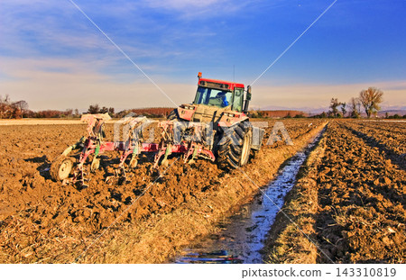 Tractor Plowing Farmland in Rural Agricultural Landscape Tractor Plowing Farmland in Rural Agricultural Landscape 143310819