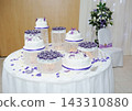 Wedding Cake Dessert Table with Purple Floral Decorations 143310880