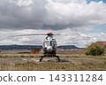 Helicopter parked on landing pad in rural landscape 143311284