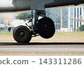 Airplane landing gear on runway 143311286