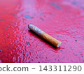 Cigarette on wet red surface 143311290