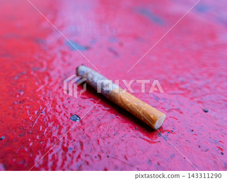 Cigarette on wet red surface 143311290