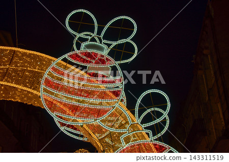 Giant Christmas baubles with red and white LED lights suspended above the streets of downtown Vigo during the famous Christmas lights display. Giant Christmas baubles with red and white LED lights suspended above the streets of downtown Vigo during the famous Christmas lights display. 143311519