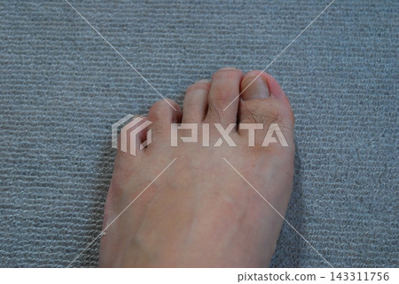 Close-up of bare feet on a carpet Close-up of bare feet on a carpet 143311756