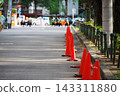 Red traffic cones lined up along the side of the road 143311880