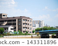 Apartment buildings and a river under a blue sky. 143311896