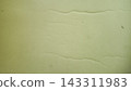 Minimalist background of a textured plaster wall surface featuring a soft olive green and sage tone. The clean concrete structure showcases subtle organic lines, waves, and fine grain details with a g 143311983