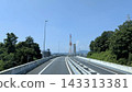 Elevated road with a view of power transmission towers under a blue sky 143313381