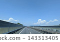 A highway stretching straight ahead under a blue sky and cumulus clouds. 143313405