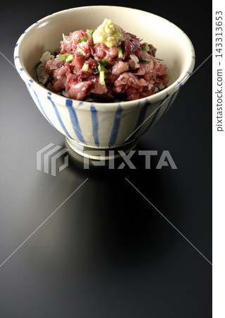 A photo of a tuna bowl against a black background. A photo of a tuna bowl against a black background. 143313653