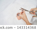 Hands Trimming Numbered Paper Measuring Strip Beside Wrapped Pattern Roll On White Treatment Bed 143314368