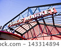 The building's exterior, marked by a red sign against a blue sky, is located at the entrance of the Granville Island Public Market in Vancouver, Canada. 143314894