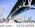 Low-angle view of the steel structure of the Buller Street Bridge above False Creek in Vancouver, Canada, and the area beneath the bridge. 143314898