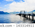 Wooden boardwalk and ferry terminal extending beneath the clouds along the Howe Bay Coastal Highway in British Columbia, Canada. 143314911
