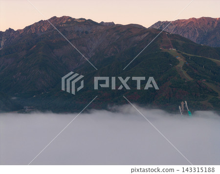 A sea of clouds and the morning glow on Mt. Karamatsu in the early morning, Hakuba Village, Nagano Prefecture (aerial photograph taken by drone) A sea of clouds and the morning glow on Mt. Karamatsu in the early morning, Hakuba Village, Nagano Prefecture (aerial photograph taken by drone) 143315188