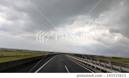 一條公路蜿蜒穿過鄉村地區,天空陰雲密布。 一條公路蜿蜒穿過鄉村地區,天空陰雲密布。 143315613