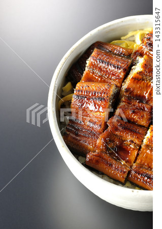 一張鰻魚飯的照片,背景為黑色。 一張鰻魚飯的照片,背景為黑色。 143315647