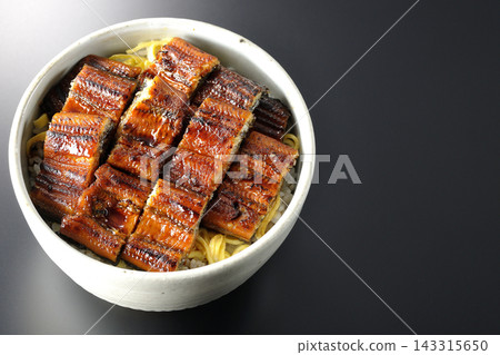 一張鰻魚飯的照片,背景為黑色。 一張鰻魚飯的照片,背景為黑色。 143315650