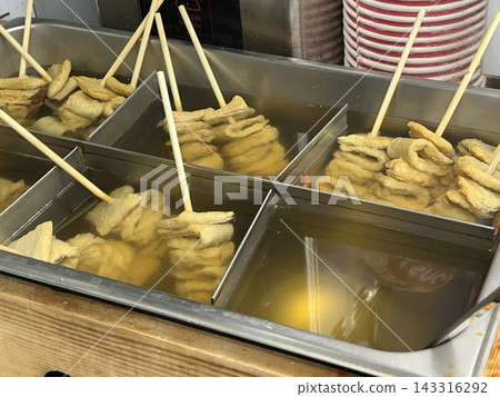 Odeng, a popular Korean street food made from seasoned fish cake, skewered and served in a warm, savory broth. Often paired with dipping sauces, it's a comforting and flavorful snack enjoyed anytime. 143316292
