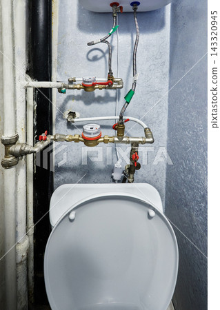 Water meter assembly includes brass utility valves and flexible hoses connected directly to domestic storage water heater installed inside residential room. Water meter assembly includes brass utility valves and flexible hoses connected directly to domestic storage water heater installed inside residential room. 143320945