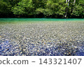 The Azusa River in Kamikochi shines with an emerald green, crystal-clear water that allows you to see the stones on the riverbed. 143321407