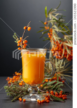 Glass mug of sea buckthorn tea with fresh berries and thyme. Glass mug of sea buckthorn tea with fresh berries and thyme. 143321990