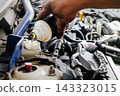 Mechanic hand servicing a car engine 143323015