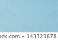 Pale cyan paper texture background with irregular grain across a blank matte blue surface 143323878