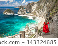 Back view woman wearing a red dress on standing on the stairs leading down at Diamond beach in Nusa 143324685