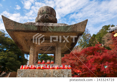 Daruma doll figures on stone lantern in Katsuo-ji temple at fall, Osaka Daruma doll figures on stone lantern in Katsuo-ji temple at fall, Osaka 143324719