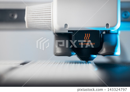 Extreme macro shot of 3D printer nozzle printing white plastic object 143324797