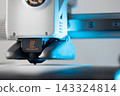 Close up of 3D printer nozzle with caution hot warning sign 143324814