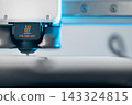 Extreme macro shot of 3D printer nozzle printing white plastic object 143324815