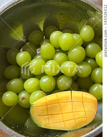 Shine Muscat grapes and ripe mango slices arranged beautifully, showcasing vibrant green and golden hues. Juicy, sweet, and refreshing, creating a tropical and visually striking fruit combination. Shine Muscat grapes and ripe mango slices arranged beautifully, showcasing vibrant green and golden hues. Juicy, sweet, and refreshing, creating a tropical and visually striking fruit combination. 143326312