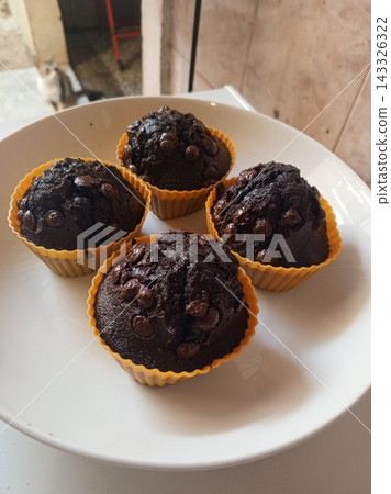 Soft chocolate muffin with a moist crumb and rich cocoa flavor. Gently domed and tender inside, offering a comforting sweetness perfect for snacks, breakfast moments, or cozy food visuals. 143326322