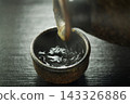 Pour hot sake into the glass. 143326886