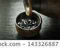 Pour hot sake into the glass. 143326887