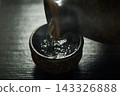 Pour hot sake into the glass. 143326888