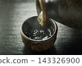Pour hot sake into the glass. 143326900