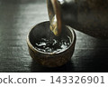 Pour hot sake into the glass. 143326901