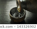 Pour hot sake into the glass. 143326902